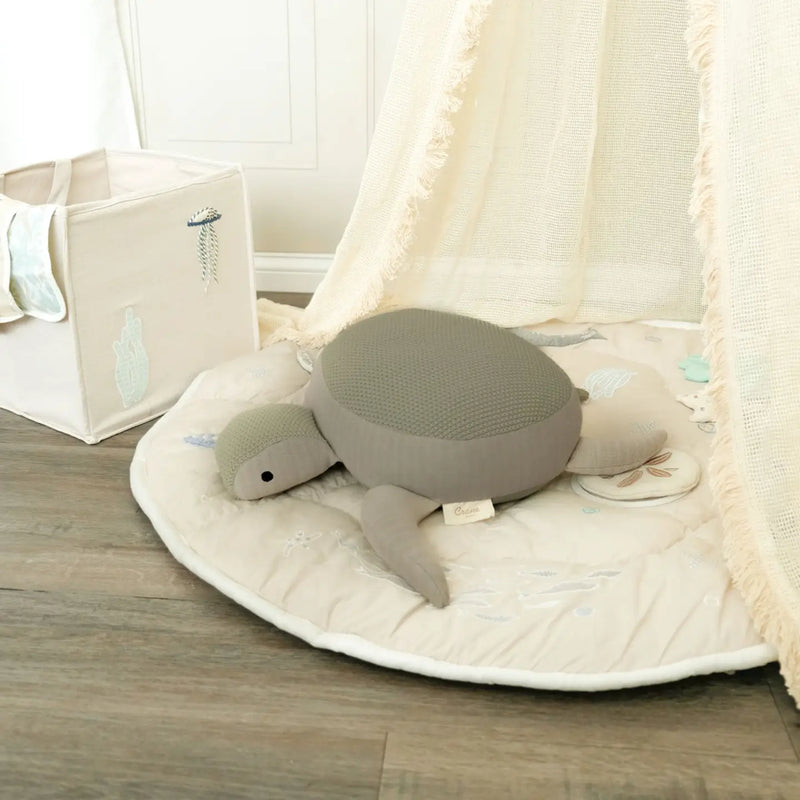 knit cotton crane baby stuffed animal toy laying on crane baby play mat 