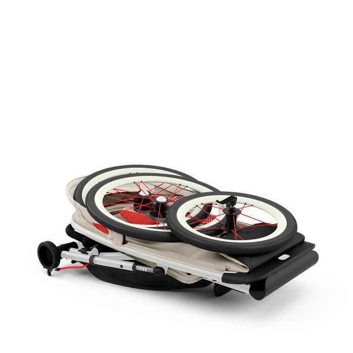 Cybex Avi Bleached Sand folded jogger stroller, chic and durable for outdoor adventures.