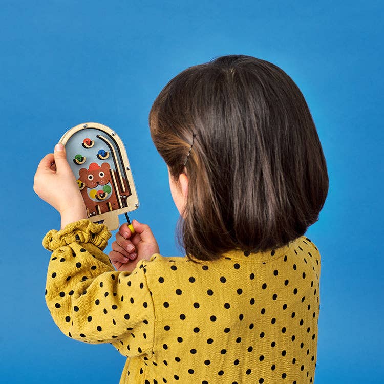 Child playing with wooden pinball children's game bear version