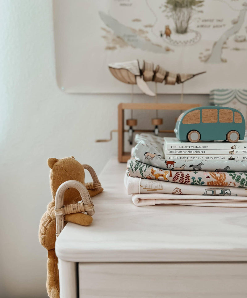 stack of apple park nursery decor including bamboo baby blanket 