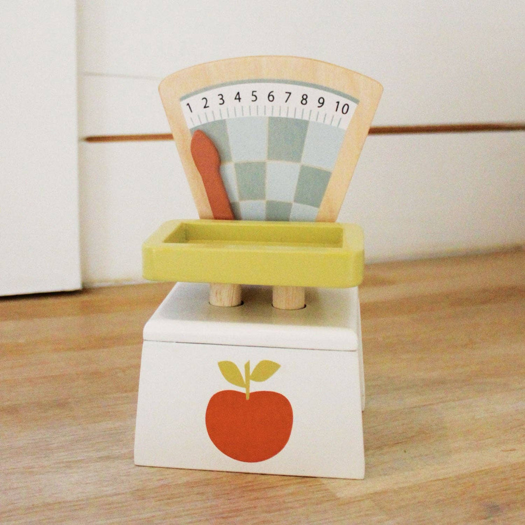 Tender Leaf Toys Market Scales resting on a sunlit wooden floor at home