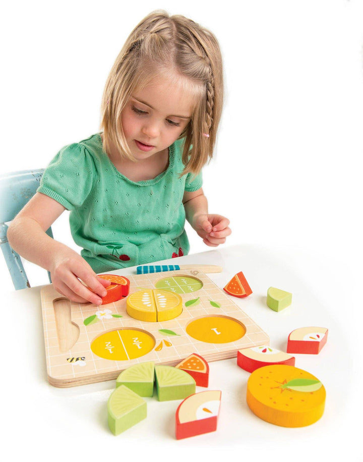 A young girl practices early math skills playing with the Tender Leaf Toys Citrus Fractions set