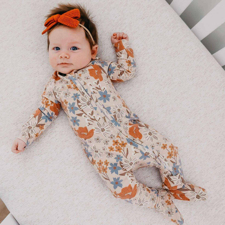 Baby wearing Copper Pearl Eden pajamas lying on blanket, soft infant sleepwear for comfort and movement