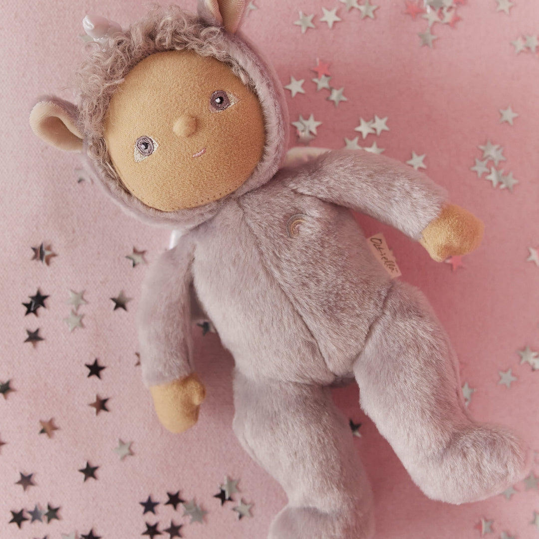 Dinkum Dolls Uma Unicorn palm-sized doll lying on a pink blanket with star confetti