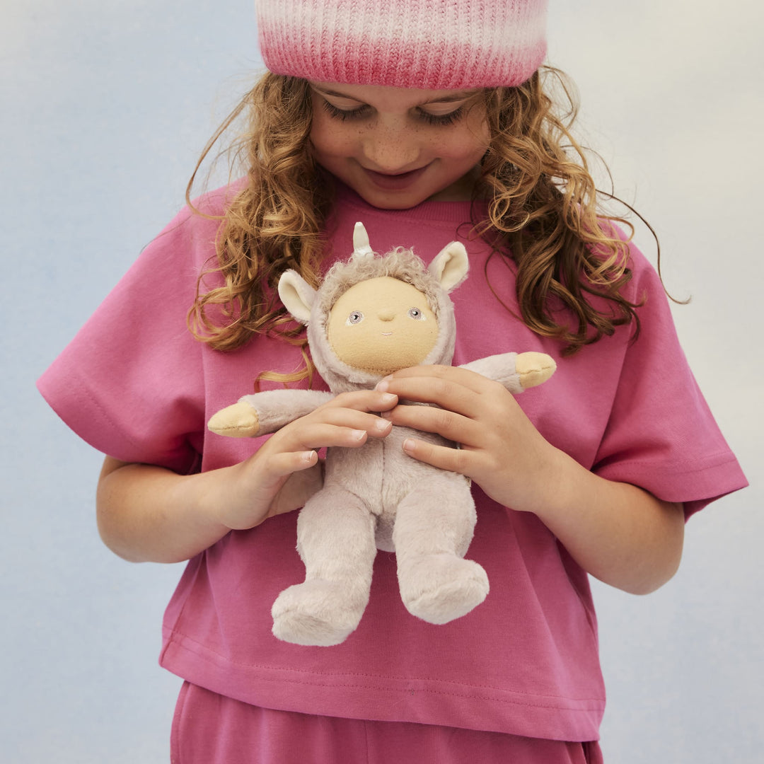 Child holding the Dinky Dinkums Uma Unicorn lilac collectible doll from Dinkum Dolls