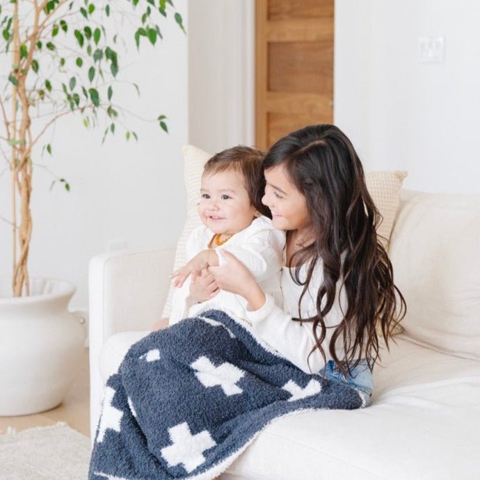 Made for endless cuddles, the Saranoni Double-Layer BAMBONI¨ Mini Blanket in Charcoal Swiss Cross stands out as one of the best toddler blankets.