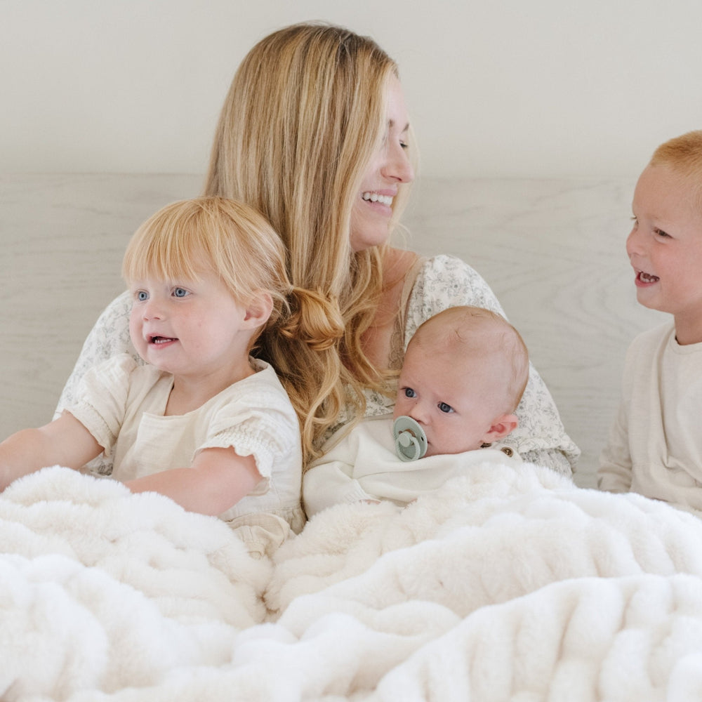 Snow brings a luxe Saranoni Double Ruched Faux Throw Blanket look that shoppers love when choosing high end Baby blankets.