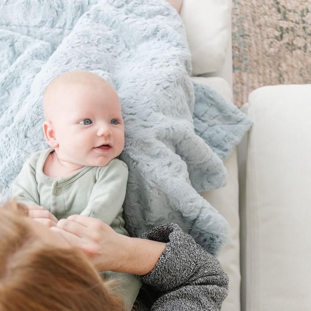 The Saranoni Dream Receiving Blanket in Heather Blue surrounds your baby in warmth and love, the best blanket for gentle sleep.