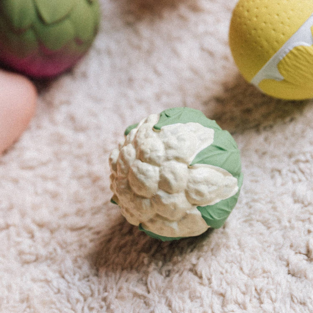 Close up of cauliflower and pumpkin balls included in Oli & Carol Veggie Soup Baby Sensory Balls