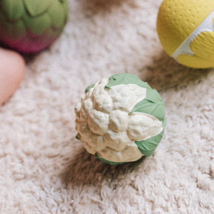Close up of cauliflower and pumpkin balls included in Oli & Carol Veggie Soup Baby Sensory Balls