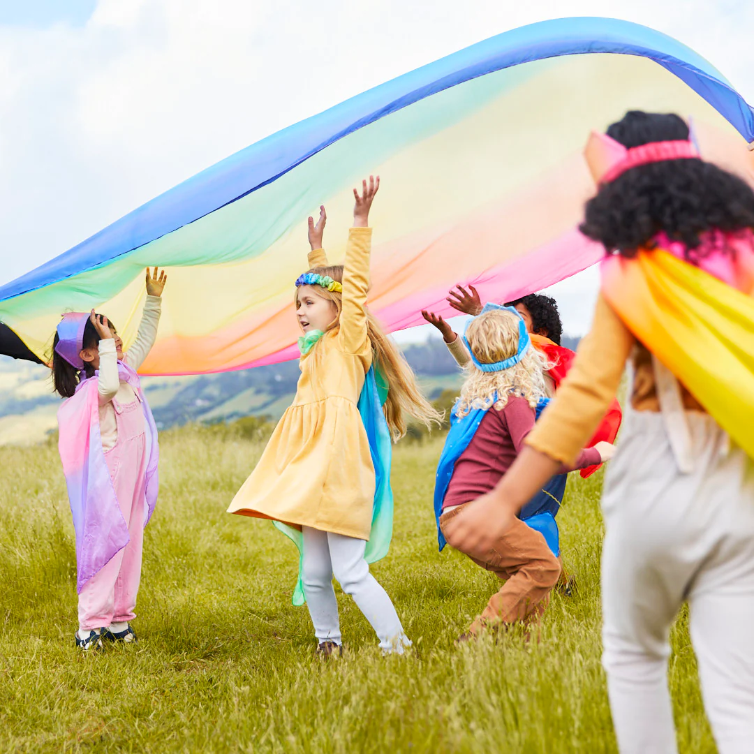 Sarah's Silks brings groups of children together under a flowing rainbow silk for group play