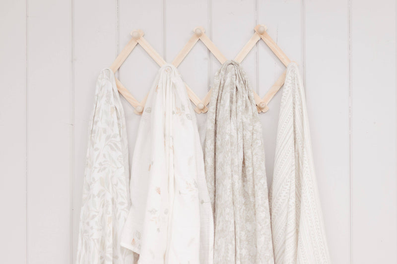 willow crane baby organic cotton swaddles hanging on beach wood background 