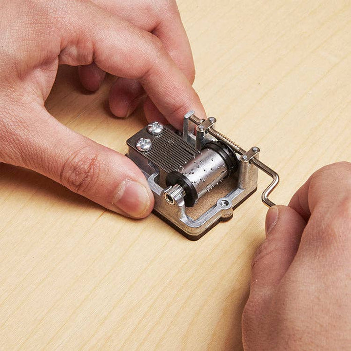 person using Here Comes The Sun hand crank music box close-up