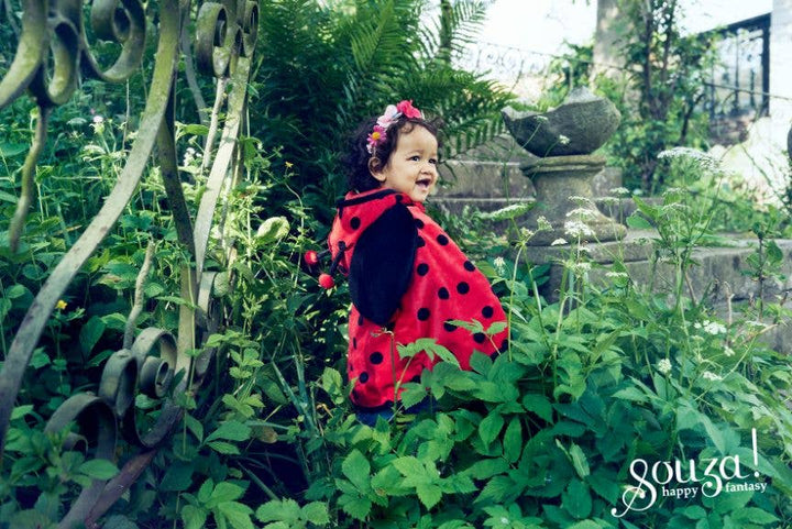 Child in a garden wearing the Souza Ladybug costume with black polka dots