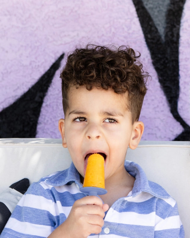 In a lifestyle scene, the Indigo EZPZ Happy Pops encourages toddlers to try new foods with its fun silicone baby feeding set