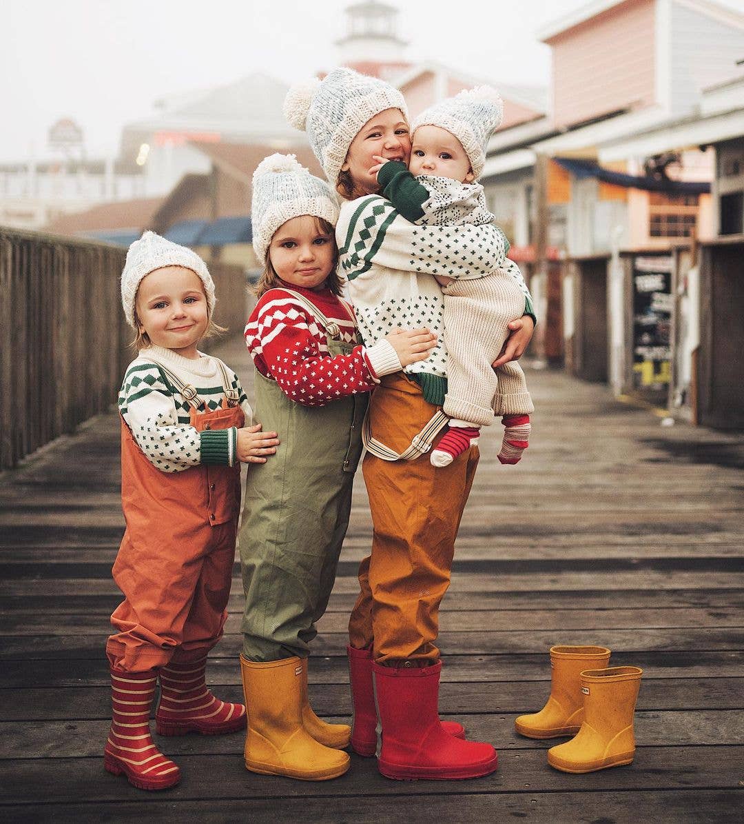 family of children wearing matching huggalugs knit sweaters and winter forest beanie 