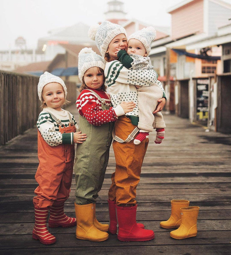 family of children wearing matching huggalugs knit sweaters and winter forest beanie 