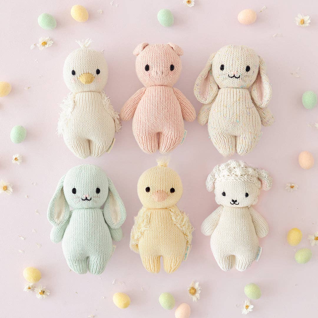 showcase of multiple cuddle + kind stuffed baby animal toys in pastel colors
