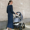 mother pushing infant stroller uppababy