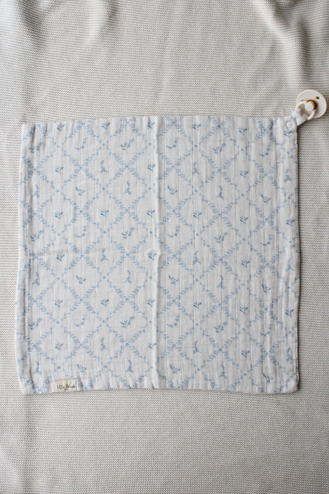 Little Threads baby lovey laid flat from above showing quilted blue lattice texture