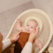 Mushie organic cotton washcloths December flat lay - five-pack muslin baby washcloths styled with bath time essentials