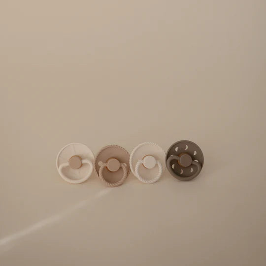 FRIGG Crystal Sparkling silicone pacifier flat lay - sparkling-toned orthodontic soothers on minimal background