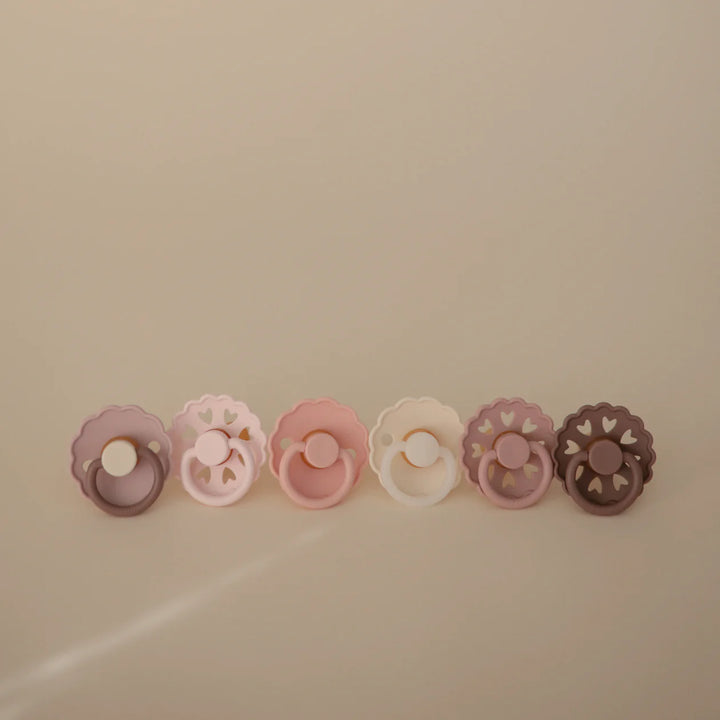 FRIGG Blooming Love rubber pacifier 6-pack flat lay - blush and rose latex soothers on white background