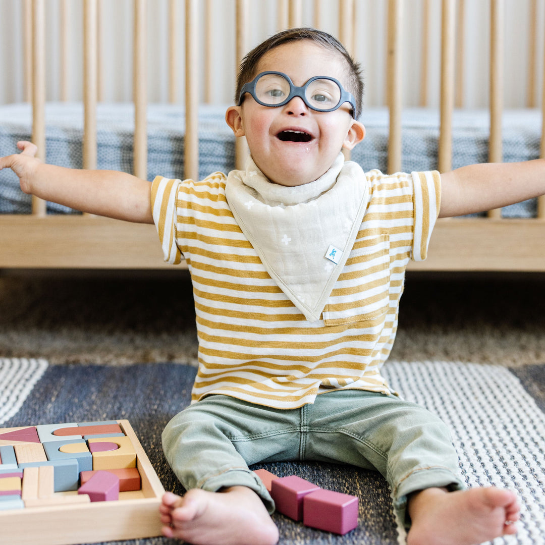 Side angle of Little Unicorn Cotton Muslin + Fleece Bandana Bib 4 Pack - Mauve Stripe, must-have baby bib for messy moments.