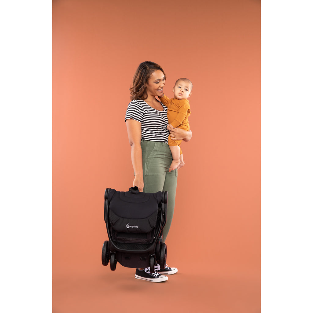 mom holding ergo baby stroller and baby