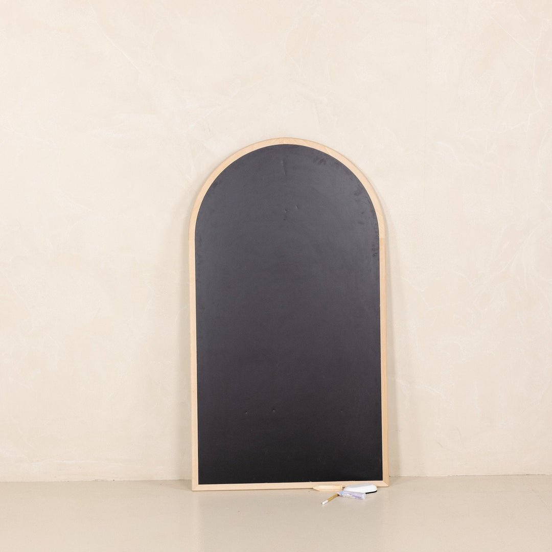 Arched chalkboard from Gathre leans against a wall, framed in natural wood for playroom decor