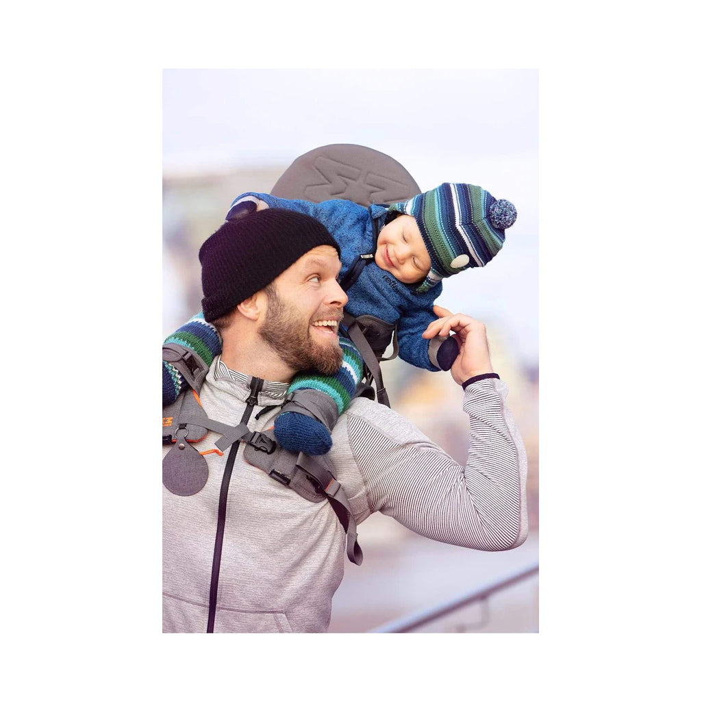Happy child in the grey shoulder carrier