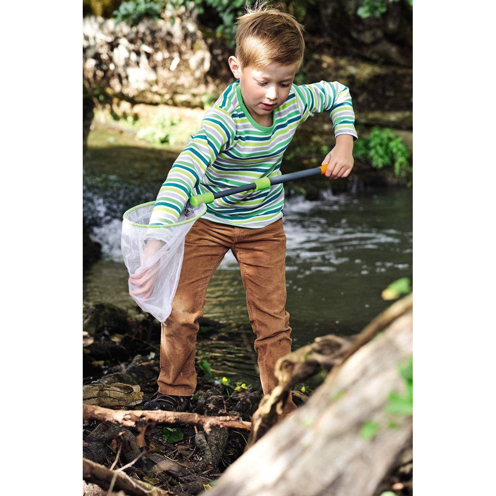 Boy playing in the river with kids scoop net.