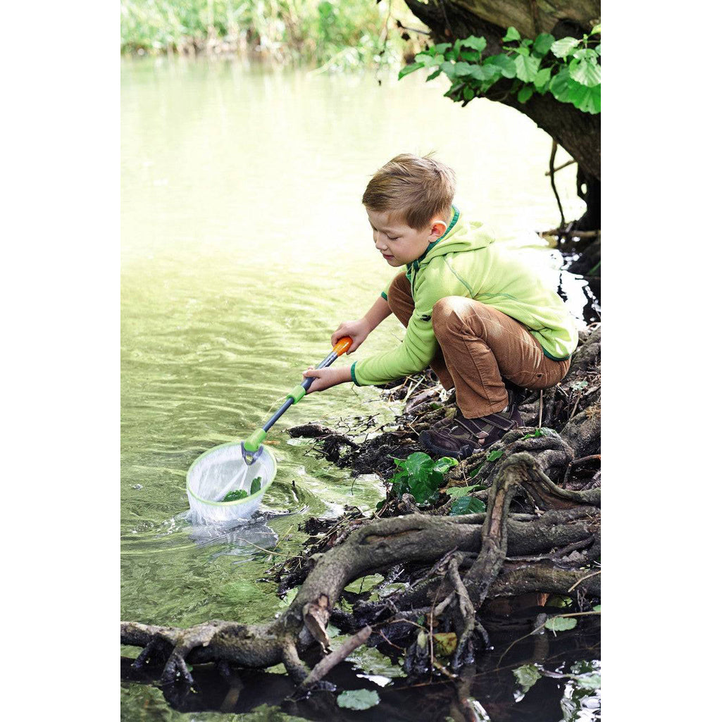 Young boy playing outdoors with water net.