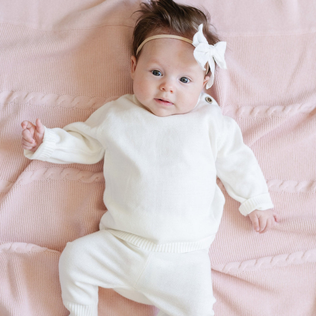 Made for everyday comfort, the Cream Saranoni Heirloom Cotton Knit Set blends luxury and practicality in baby clothing.