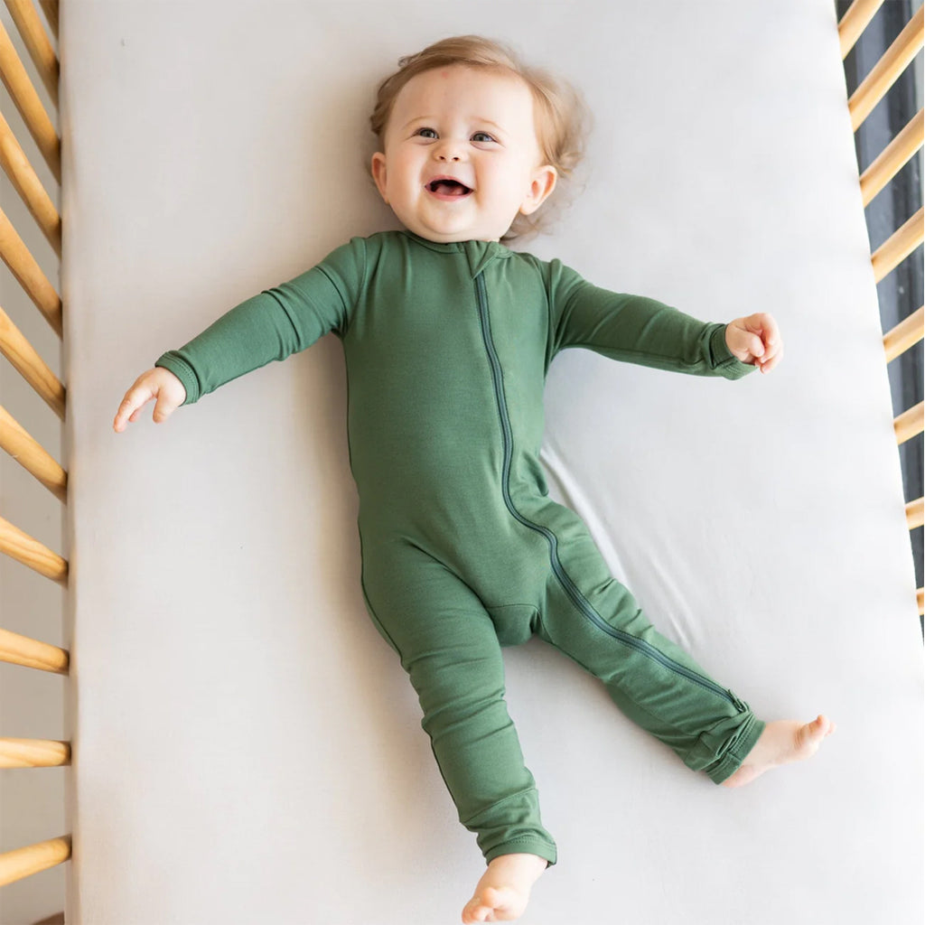Happy baby in the Kyte Zipper Romper in the shade hunter.