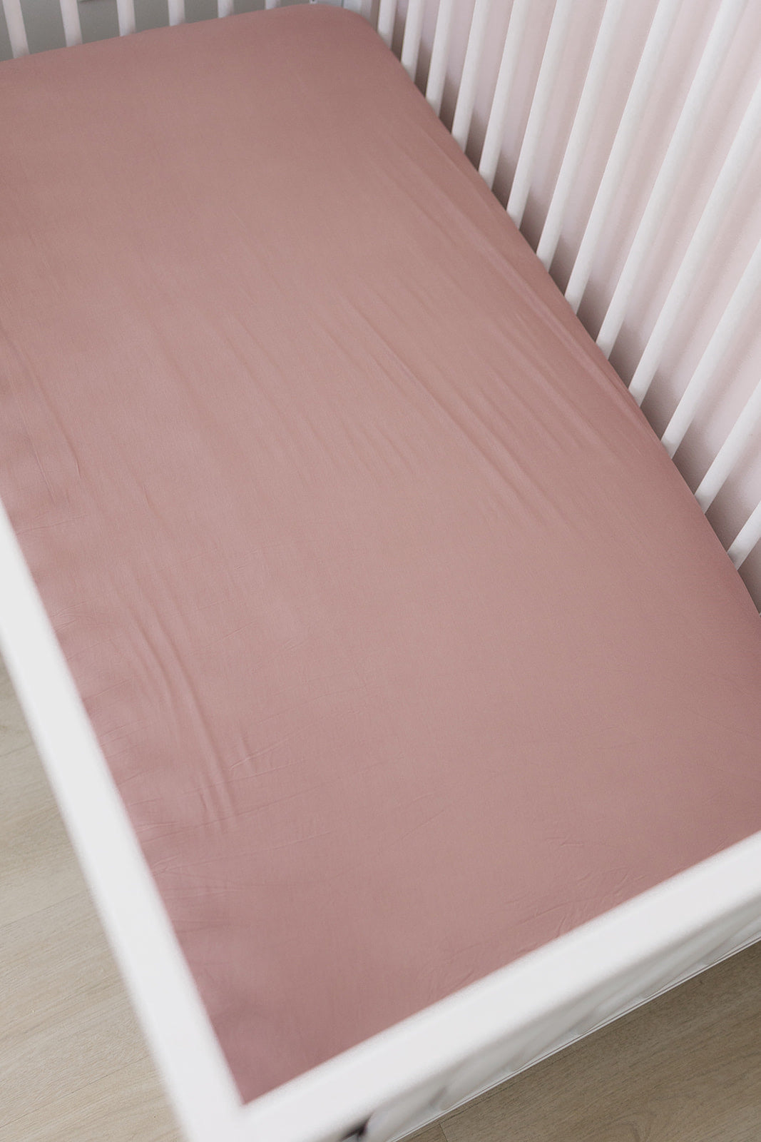 Shown up close to highlight the stretchy bamboo fabric, the Mebie Baby Dusty Rose Bamboo Stretch Crib Sheet.