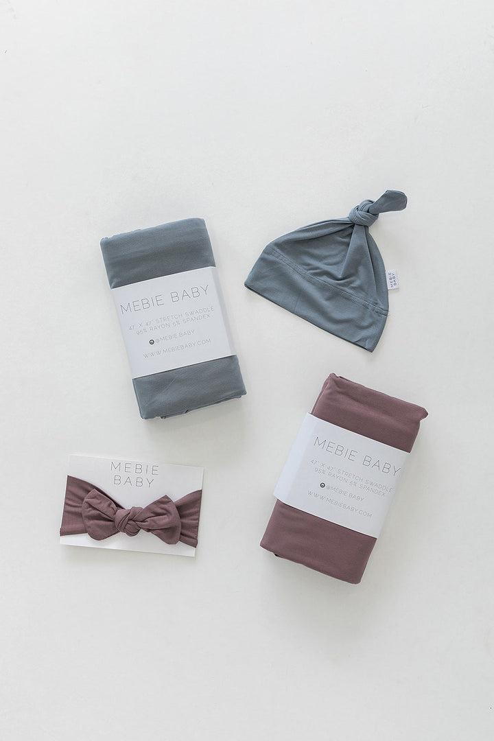 Mebie Baby Dusty Blue Bamboo Stretch Swaddle held up to show the soft stretch fabric.