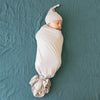 baby swaddled and wearing Kyte Baby oat baby hat