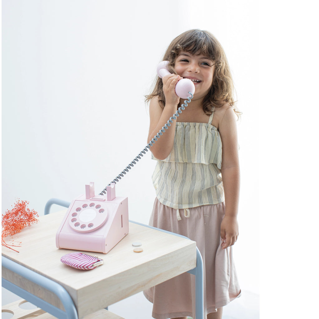 kid with wooden telephone retro toy