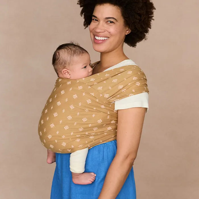 Capture serene moments with the Ergobaby Aura Baby Wrap in Camel Harvest, featured here as a gentle baby swaddle wrap.