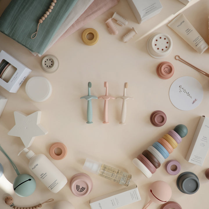 Assorted Training Toothbrushes in Array of Colors A collection of Mushie training toothbrushes in a variety of fun colors