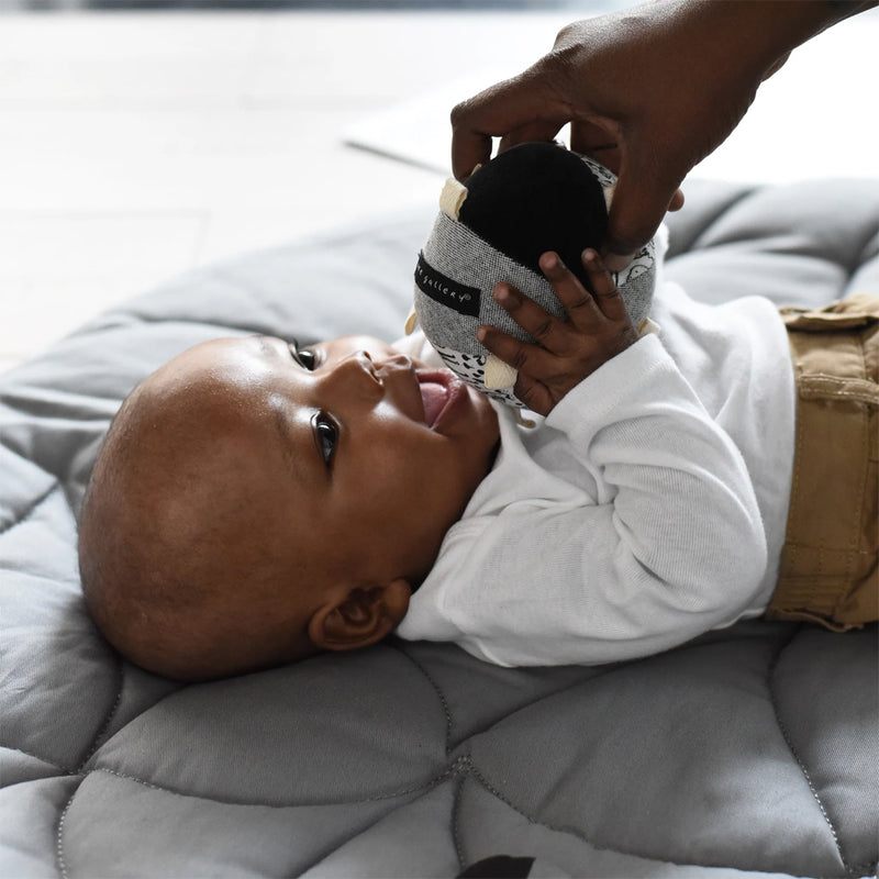 Baby playing with taggy ball by wee gallery