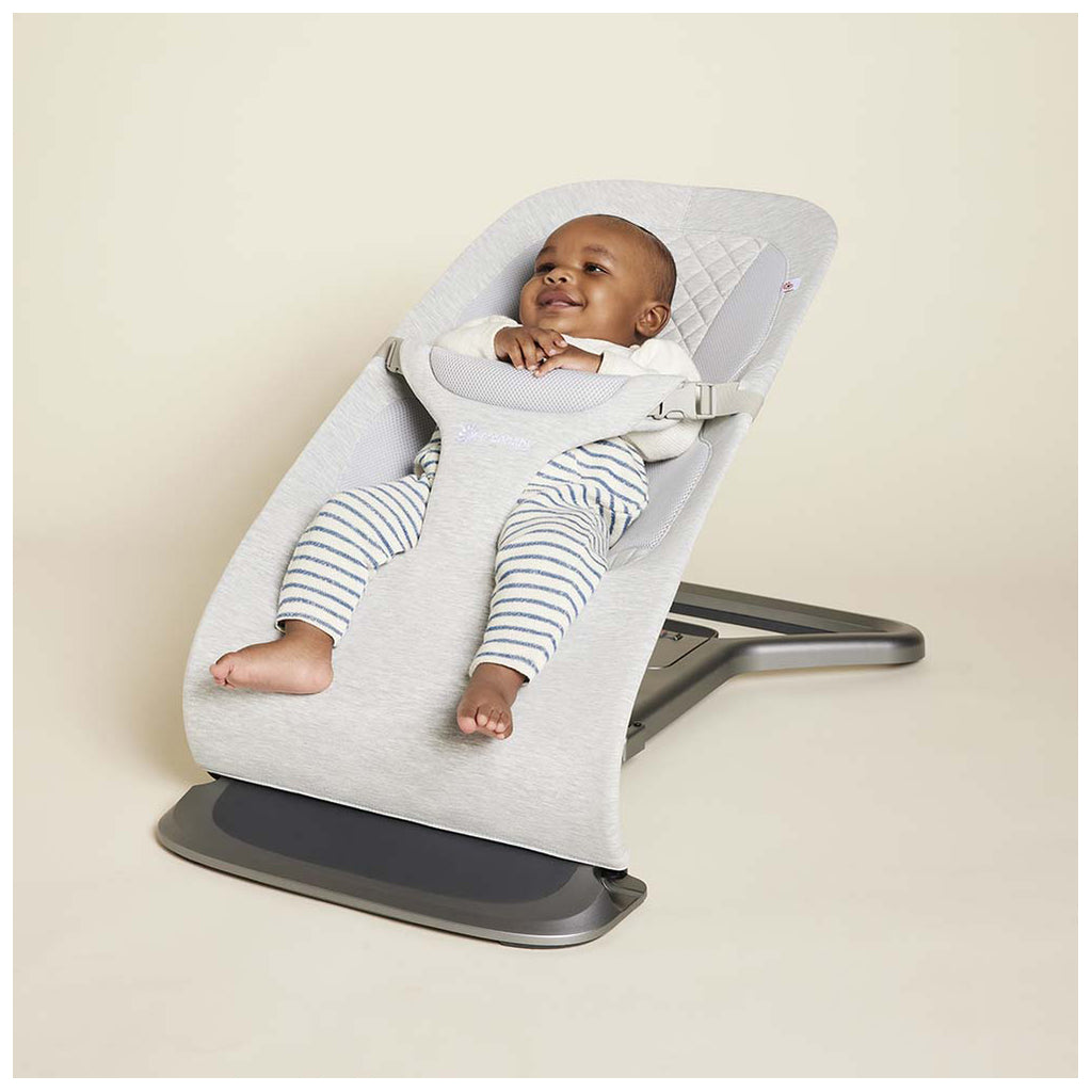 Infant sitting in the Ergo baby bouncer in ight grey
