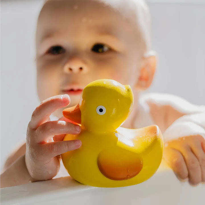 Infant enjoying CaaOcho rubber duck, one of the best baby bath toys for sensory development.