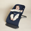 Baby sitting in the midnight blue Ergobaby evolve bouncer