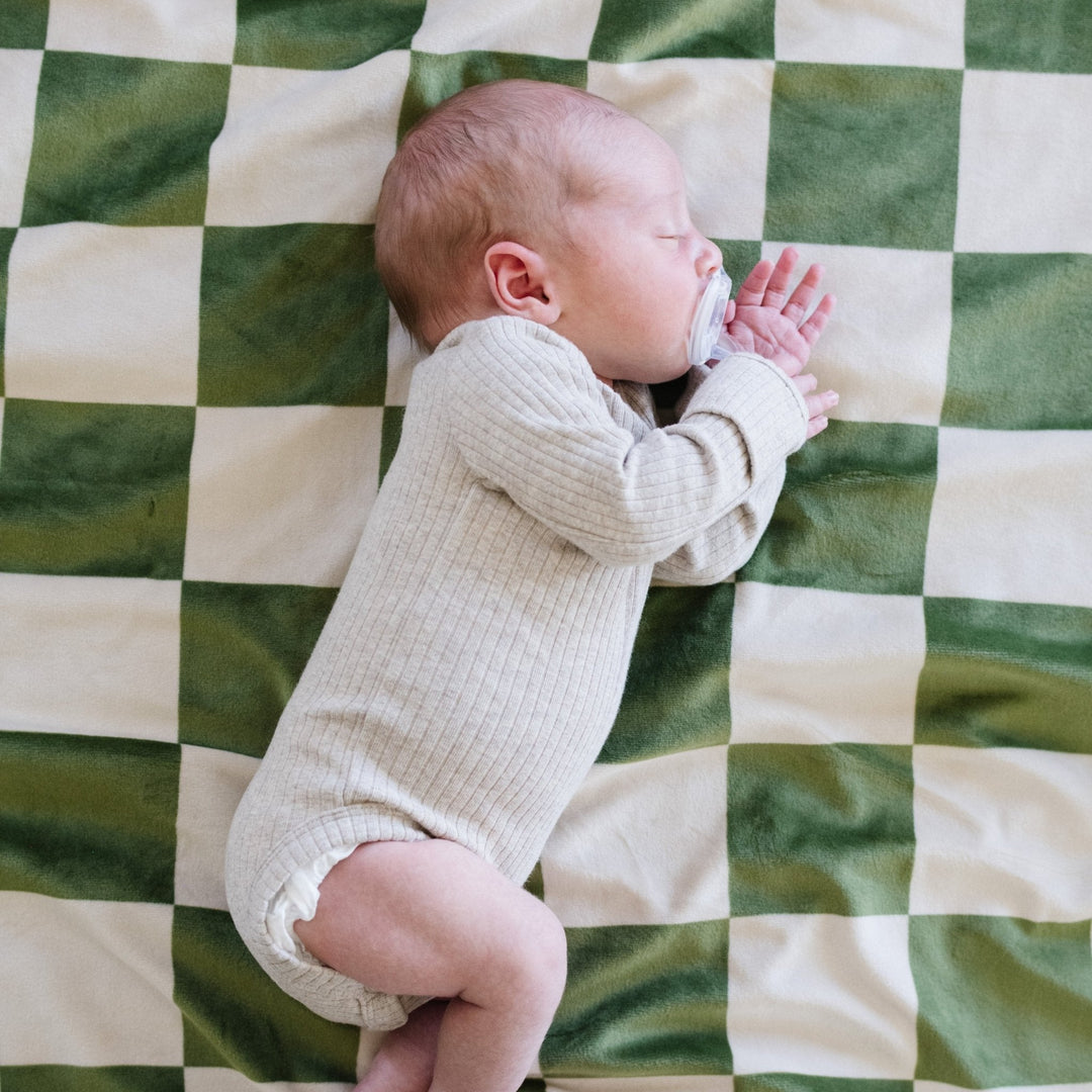 Soft to the touch, the Saranoni Minky Stretch Receiving Blanket in Olive Checkered is designed for cozy nights and infant comfort.