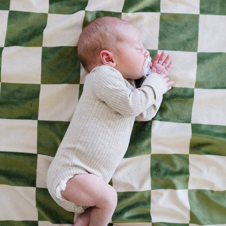 Soft to the touch, the Saranoni Minky Stretch Receiving Blanket in Olive Checkered is designed for cozy nights and infant comfort.