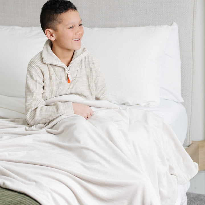 Wrap your infant in comfort with the Saranoni Minky Stretch Receiving Blanket in Buttermilk, a favorite among receiving blankets.