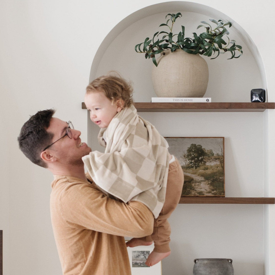 Keep your baby wrapped in warmth with the Saranoni Minky Stretch Receiving Blanket in Neutral Checkered, crafted for ultimate comfort.