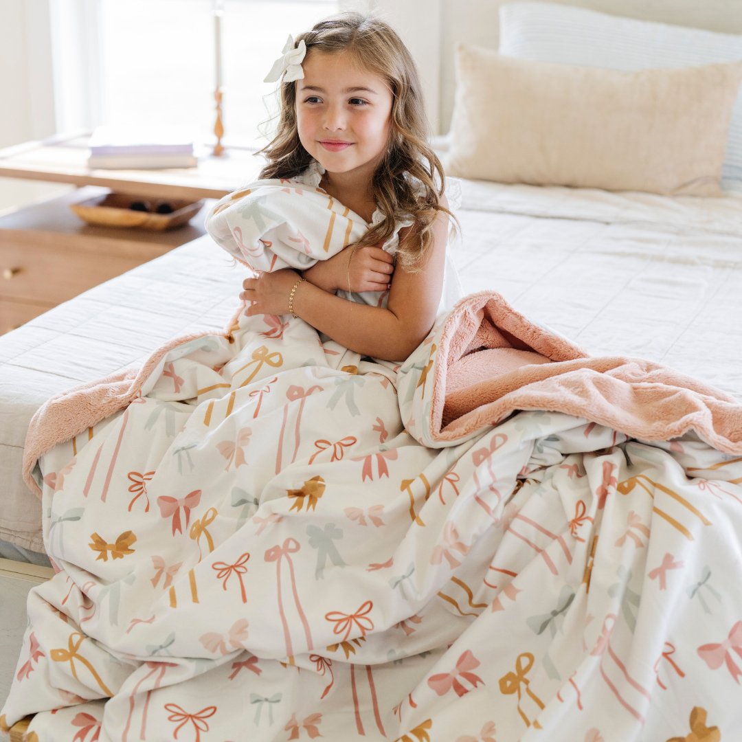 Baby girl blankets get cozy with the Minky/Lush XL Blanket In Bows from Saranoni.